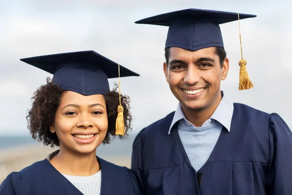 happy students or bachelors in mortar boards