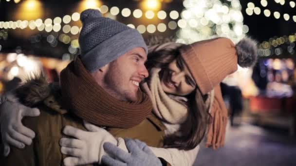 Boldog pár átölelve a karácsonyi vásár — Stock videók