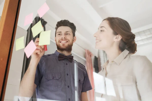 Kreativ-Team mit Aufklebern auf Glas im Büro — Stockfoto