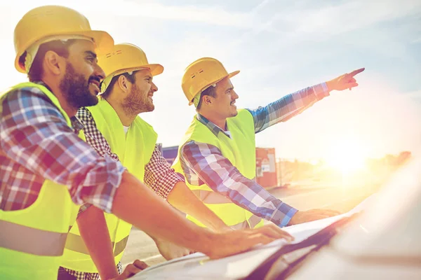 Nahaufnahme von Bauarbeitern mit Blaupause auf der Motorhaube — Stockfoto
