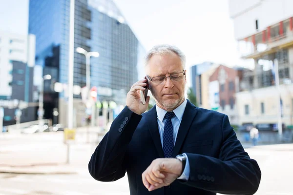 Senior affärsman ringer på smartphone i staden — Stockfoto