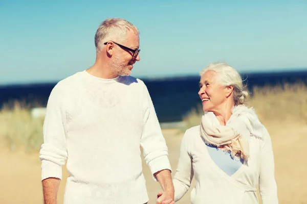 Glückliches Senioren-Paar hält Händchen am Sommerstrand — Stockfoto
