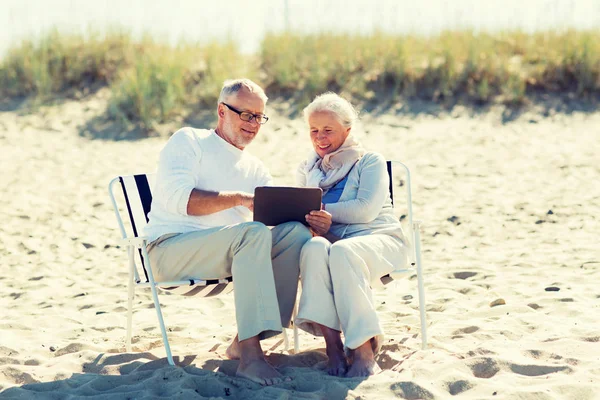 Gelukkige senior paar met de tablet pc op zomer strand — Stockfoto