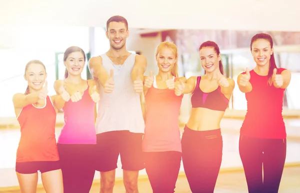 Grupp människor i gymmet visar tummen — Stockfoto