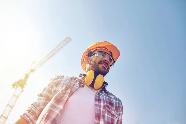 Lächelnder Bauarbeiter mit Hut und Kopfhörer — Stockfoto