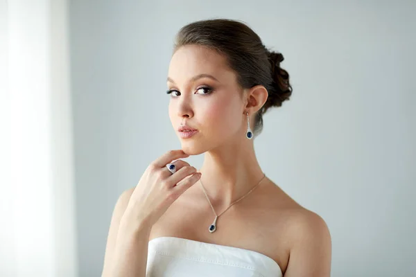 Hermosa mujer con pendiente, anillo y colgante — Foto de Stock