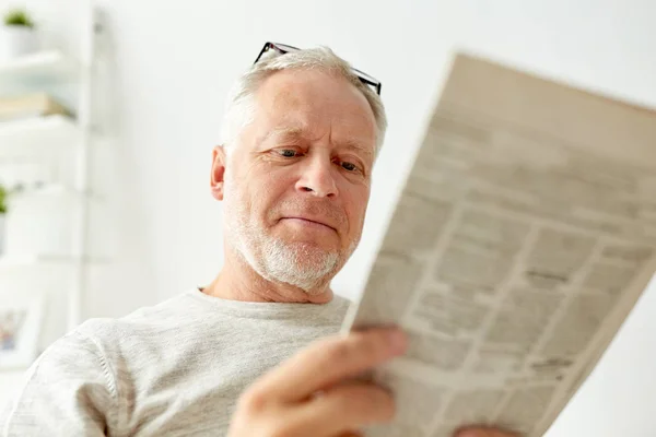 Närbild av ledande man läsa tidningen hemma — Stockfoto