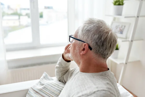 Senior mit Brille denkt zu Hause — Stockfoto