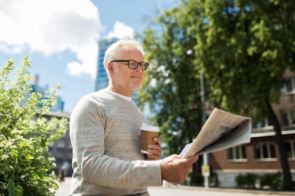 Homem sênior lendo jornal e beber café — Fotografia de Stock