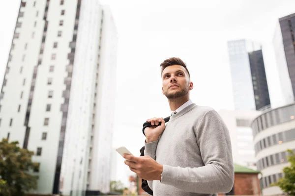 Junger Mann mit Tasche und Smartphone in der Stadt — Stockfoto