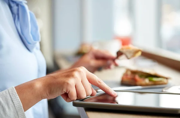 Woman with tablet pc and panini sandwich at cafe — Stock Photo, Image
