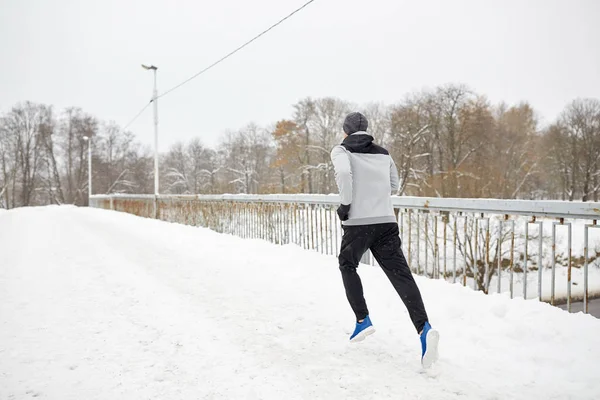 Άνθρωπος που τρέχει κατά μήκος χιόνι καλύπτονται χειμώνα γέφυρα δρόμο — Φωτογραφία Αρχείου