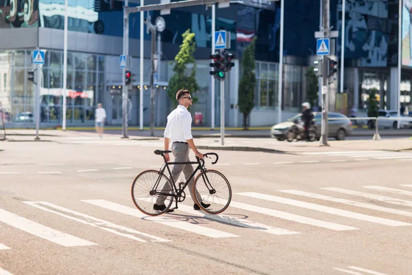 Młody człowiek z rowerem na przejściu dla pieszych w mieście — Zdjęcie stockowe