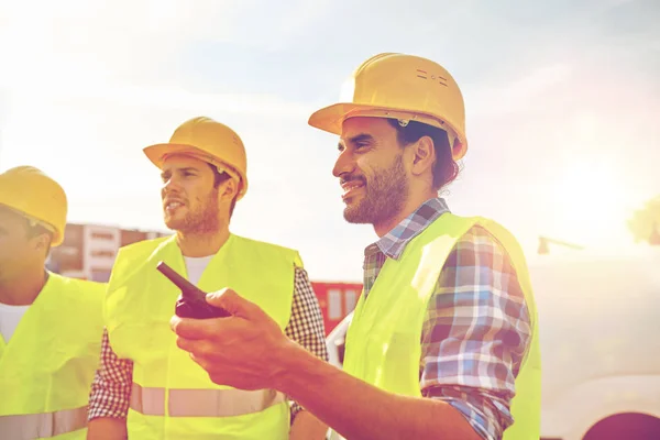 Heureux constructeurs masculins en gilets avec talkie walkie — Photo