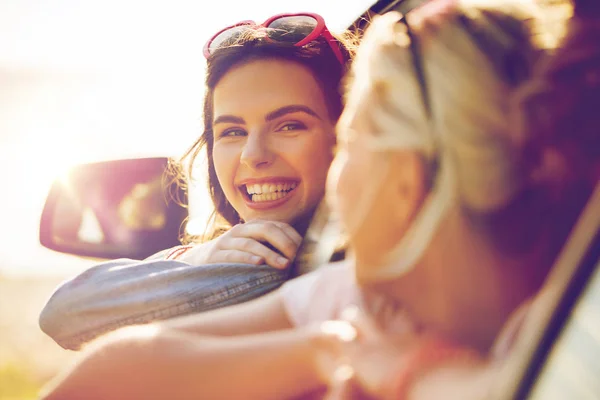 Happy teenage girls or women in car at seaside — Stock Photo, Image