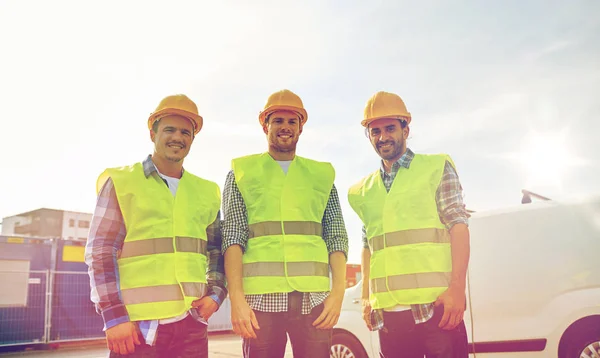 Felici costruttori maschili in giubbotti alti visibili all'aperto — Foto Stock