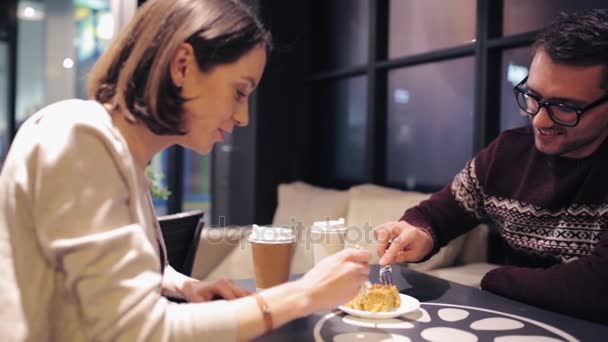 Feliz pareja comiendo pastel de postre en la cafetería — Vídeos de Stock