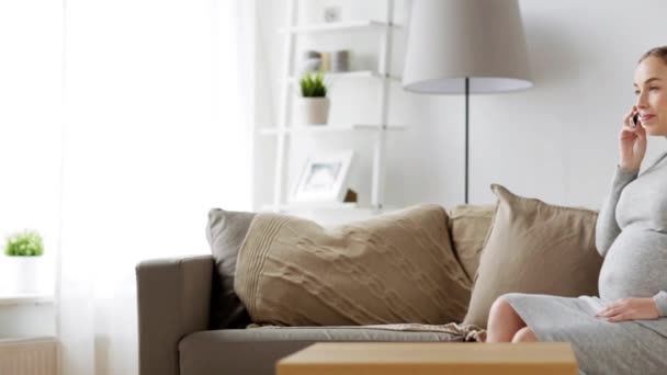 Mujer embarazada feliz llamando en el teléfono inteligente en casa — Vídeo de stock