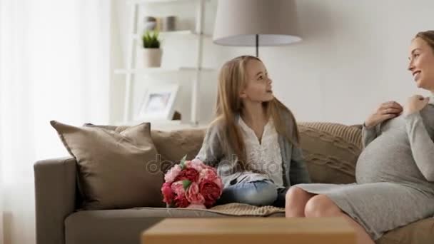 Girl giving flowers to her pregnant mother at home — Stock Video