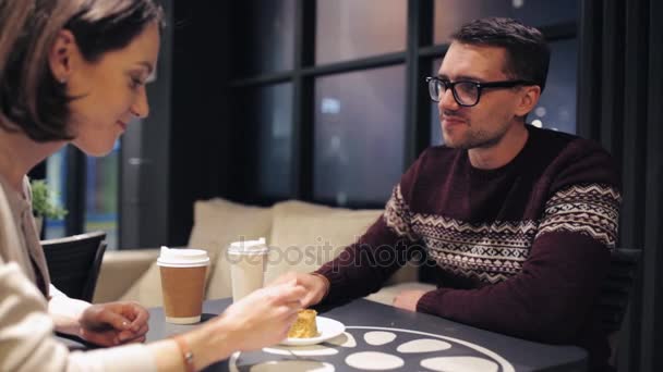 Пара ест торт и пить кофе в кафе — стоковое видео