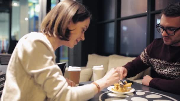 Feliz pareja comiendo pastel de postre en la cafetería — Vídeos de Stock