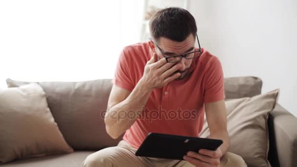 Man with tablet pc tired from eyeglasses at home — Stock Video