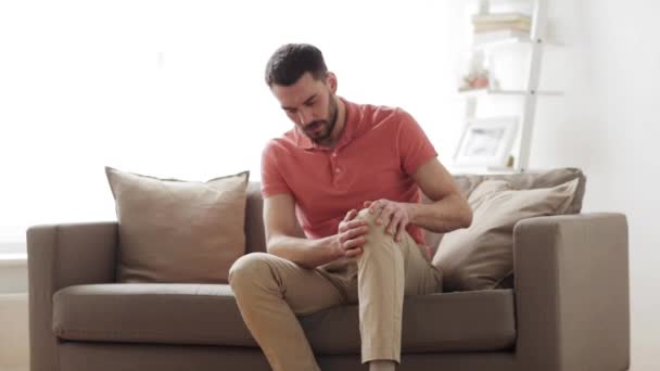 Ongelukkige man lijden aan pijn in het been thuis — Stockvideo