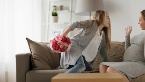 Mädchen schenkt ihrer schwangeren Mutter zu Hause Blumen — Stockvideo