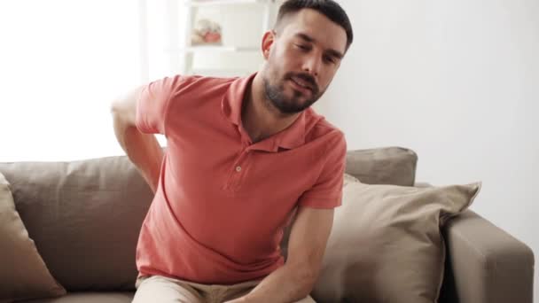 Homem infeliz sofrendo de dor nas costas em casa — Vídeo de Stock