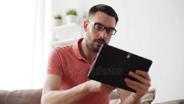 Man with tablet pc tired from eyeglasses at home — Stock Video