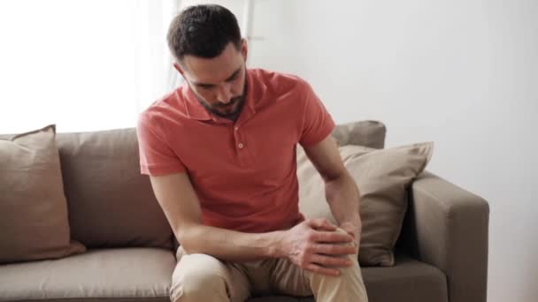 Homme malheureux souffrant de douleur à la jambe à la maison — Video