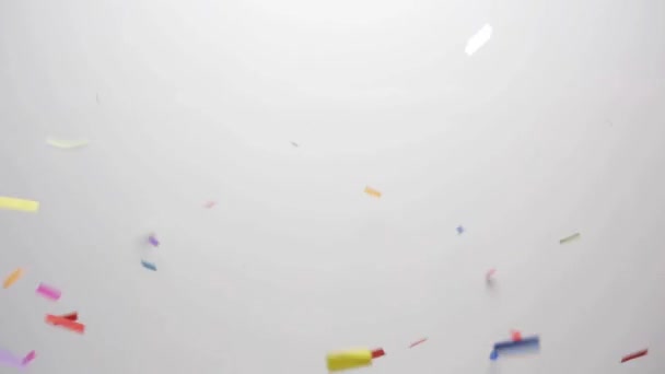Конфетти, падающие на белом фоне — стоковое видео