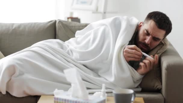 Hombre enfermo con termómetro que tiene gripe en casa — Vídeo de stock