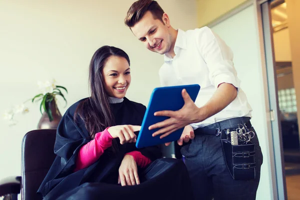 Mulher feliz e estilista com tablet pc no salão — Fotografia de Stock