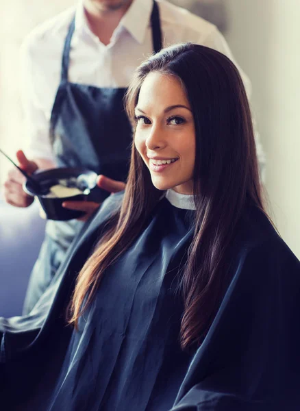 Happy young woman coloring hair at salon — Stock Photo, Image