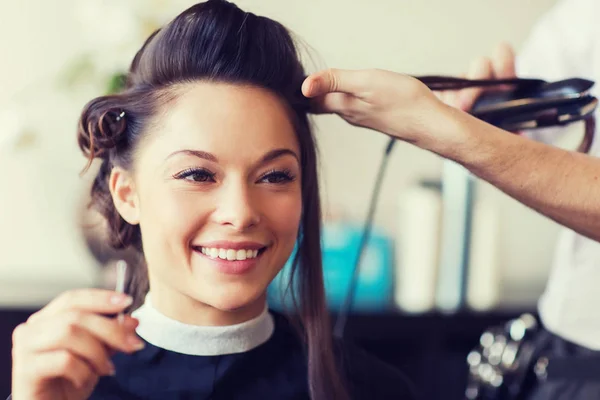 Mulher feliz com estilista fazendo penteado no salão — Fotografia de Stock