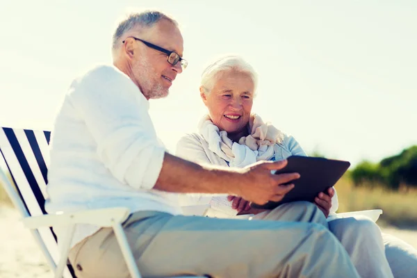 Gelukkige senior paar met de tablet pc op zomer strand — Stockfoto