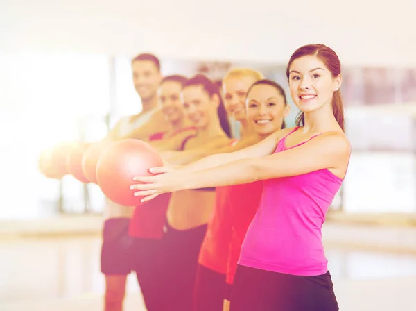 Grupo de personas sonrientes haciendo ejercicio con la pelota — Foto de Stock