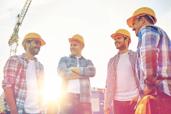 Grupa budowniczych uśmiechający się w hardhats na zewnątrz — Zdjęcie stockowe