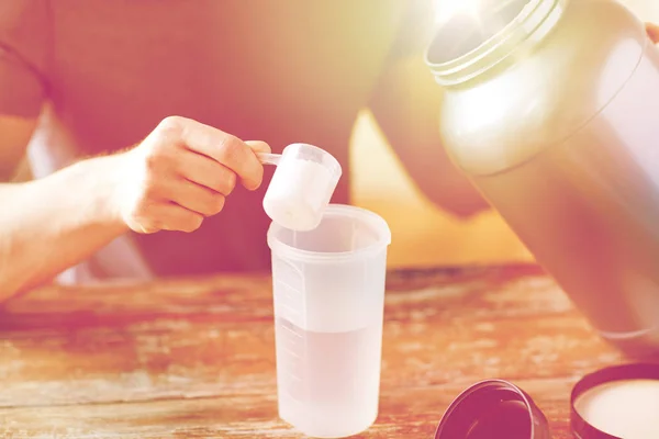 Primer plano del hombre con botella de batido de proteínas y frasco —  Fotos de Stock