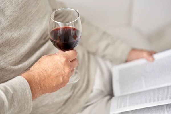 Close up of senior man with wine glass and book — Stock Photo, Image