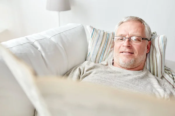 Nahaufnahme eines älteren Mannes, der zu Hause Zeitung liest — Stockfoto