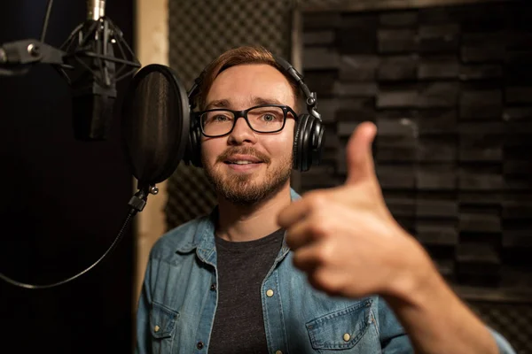 Uomo con le cuffie che canta in studio di registrazione — Foto Stock