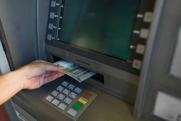 Primer plano de la mano retirar dinero en la máquina de cajero automático —  Fotos de Stock