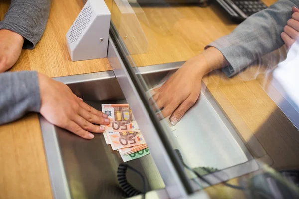 Verkäuferin gibt Kunden in Bankfiliale Bargeld — Stockfoto