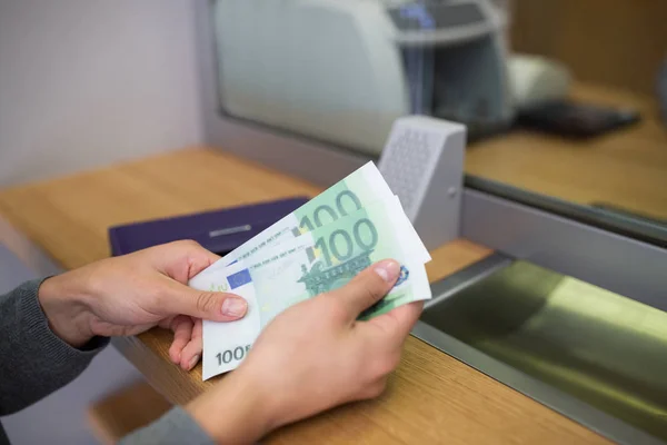 Руки с деньгами в банке или обменнике валют — стоковое фото