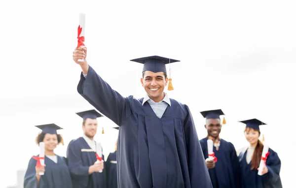 Glückliche Studenten in Mörteltafeln mit Diplomen — Stockfoto