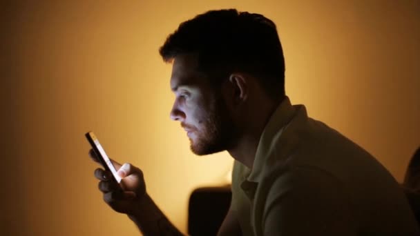 Jonge man met smartphone bij nacht — Stockvideo