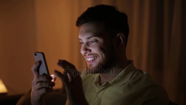 Joven feliz con teléfono inteligente por la noche — Vídeo de stock