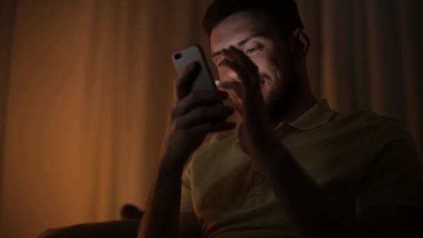 Joven feliz con teléfono inteligente por la noche — Vídeo de stock